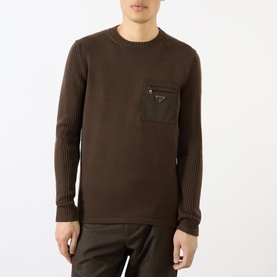Model wearing Prada brown virgin wool crew neck jumper with zip chest pocket and ribbed sleeves, styled with brown trousers