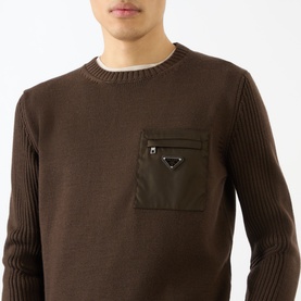 Model wearing Prada brown virgin wool crew neck jumper with nylon zip chest pocket and triangle logo badge.