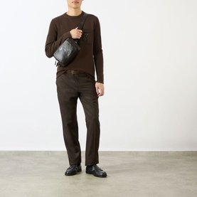 Model wearing Prada brown virgin wool crew neck jumper with matching brown trousers, styled with a black crossbody bag and black loafers.