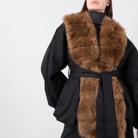 Model wearing Rotate black jacket with oversized tan faux fur collar and trim, belted waist, wide sleeves