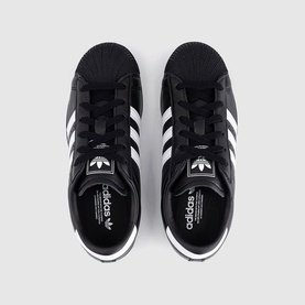 Adidas Superstar trainers in black with white three-stripe detailing, lace-up fastening, overhead flat-lay view showing both shoes