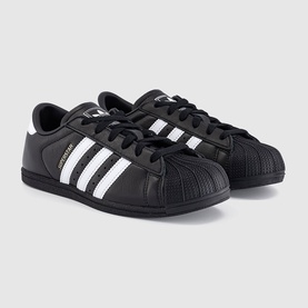Adidas Superstar trainers in black with white three stripes, shell toe, and gold metallic branding detail on black sole