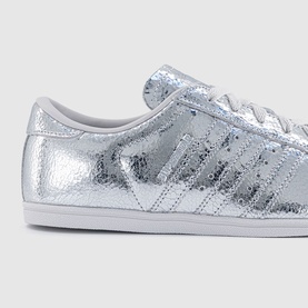 Adidas silver metallic crinkled leather low-top trainer with tonal three stripes and white rubber sole, angled detail view