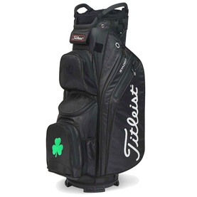 Titleist black golf cart bag with green shamrock embroidery, multiple zip pockets, stand legs, and white Titleist branding on side