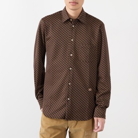 Model wearing Wales Bonner brown and caramel geometric-print casual shirt, styled with tan trousers.