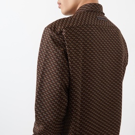Model wearing Wales Bonner casual shirt in brown and caramel geometric print, rear shoulder detail visible.