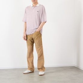 Model wearing Wales Bonner polo in Ivory/Wine stripe, styled with tan wide-leg trousers and white shoes.