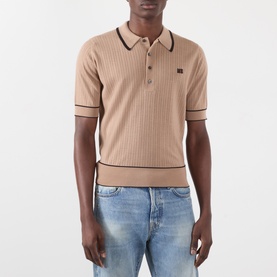 Model wearing Wales Bonner camel mohair wool polo shirt with dark tipping, ribbed texture and logo patch, styled with light blue jeans.