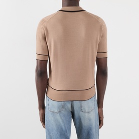 Model wearing Wales Bonner camel mohair wool polo, rear view, with dark contrast trim detailing and light blue denim jeans.