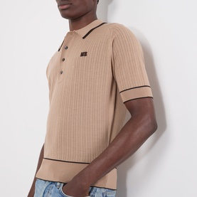 Model wearing Wales Bonner camel ribbed mohair wool polo shirt with contrast tipping and logo patch, styled with light blue jeans