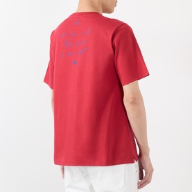 Model wearing Wales Bonner Raga Logo T-Shirt in Rooibois red, back view showing blue logo lettering graphic, crew neck, short sleeves