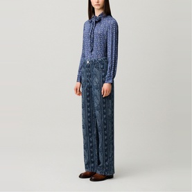 Model wearing Claude Pierlot navy print wide-leg trousers and matching printed blouse with tie neck, styled with dark loafers.
