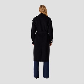 Model wearing Maje red long belted trench coat, styled with blue wide-leg jeans, rear view