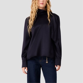 Model wearing Maje navy turtleneck long-sleeve top with relaxed fit, styled with dark denim jeans and gold charm detail.