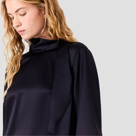 Model wearing Maje navy satin blouse with high neck and long sleeves, close-up detail shot showing draped fabric finish