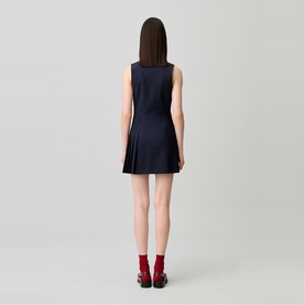 Model wearing Claude Pierlot Womens French Dress in black, sleeveless mini fit with pleated skirt, back view, styled with red socks and black shoes