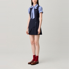 Model wearing Claude Pierlot Womens French Dress in black, styled with a striped shirt, bow tie, red socks and brown loafers