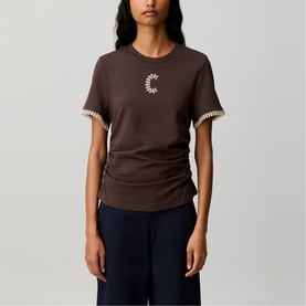Model wearing Claude Pierlot brown fitted T-shirt with moon graphic and contrast trim cuffs, styled with navy wide-leg trousers