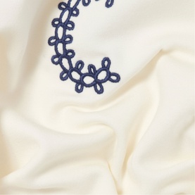 Claude Pierlot cream fabric detail with navy blue floral tatted lace trim embellishment, close-up texture shot