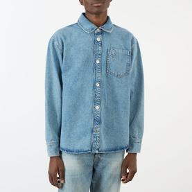 Model wearing AMI Casual Jacket in Bleu Used denim, button-front with chest pocket, styled with light wash jeans.