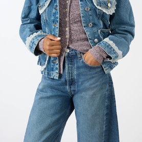 Model wearing AgoldE proof blue wide-leg denim jeans, styled with a frayed denim jacket and printed top.