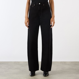 Model wearing AgoldE wide-leg black jeans in high-rise fit, styled with black leather shoes.