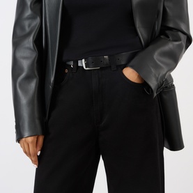 Model wearing AgoldE jeans in black with a black leather jacket and belt.