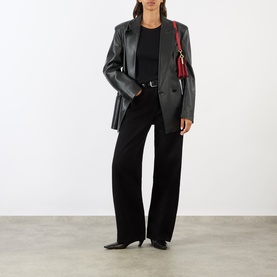 Model wearing AgoldE jeans in black, styled with a black leather blazer, black top and red crossbody bag, kitten heel shoes.