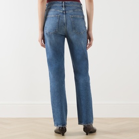 Model wearing AgoldE Straight Jeans in Waive, mid-blue wash, rear view, styled with dark ankle boots.