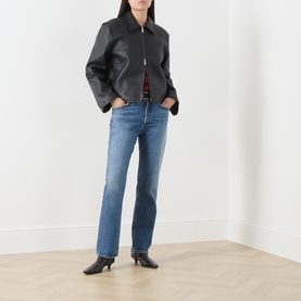 Model wearing AgoldE Waive straight jeans in mid-blue denim, styled with a black leather zip jacket and black heeled ankle boots.