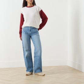 Model wearing AgoldE Straight Jeans in outbreak, wide-leg light blue denim, styled with a white and red colour-block sweatshirt.