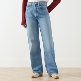 Model wearing AgolDe Straight Jeans in outbreak light blue wash, styled with a red ribbed knit top and white trainers.