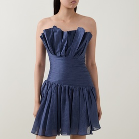 Model wearing Aje navy strapless mini dress with ruched bodice, ruffled neckline and full tiered skirt in lyocell-linen blend.