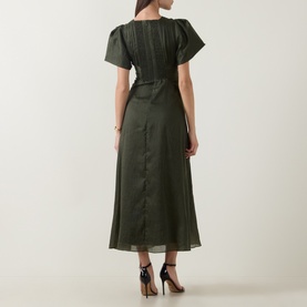 Model wearing Aje dark olive midi dress, back view, short sleeves, V-neckline, button-down back, belted waist, styled with black heels
