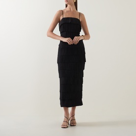 Model wearing Aje black tiered ruffle midi dress with spaghetti straps, styled with strappy heeled sandals