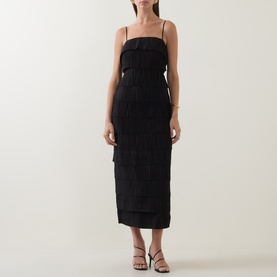 Model wearing Aje black tiered fringe midi dress with square neckline and thin straps, styled with black strappy heeled sandals