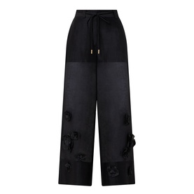 Aje black wide-leg trousers with sheer panels, floral appliqu&eacute; details, and drawstring waist