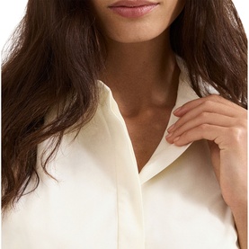 Model wearing Phase Eight white shirt dress, close-up detail of collar and button placket