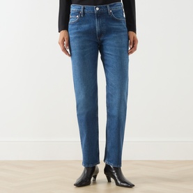 Model wearing Citizens of Humanity slim jeans in cruise blue denim, styled with black heeled ankle boots and black top.