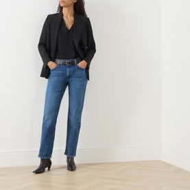 Model wearing Citizens of Humanity slim jeans in cruise blue denim, styled with black blazer, wrap top and ankle boots.