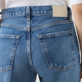 Model wearing Citizens of Humanity straight jeans in pastis blue, rear view showing back pockets and gold-tone label detail