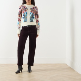 Model wearing Citizens of Humanity straight jeans in eggplant, styled with a floral print sweater and black heeled boots.