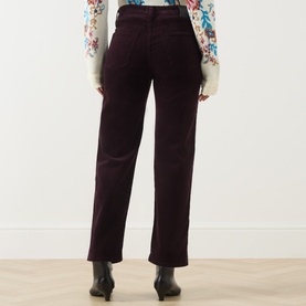 Model wearing Citizens of Humanity straight jeans in eggplant, rear view, styled with a floral blouse and black ankle boots.