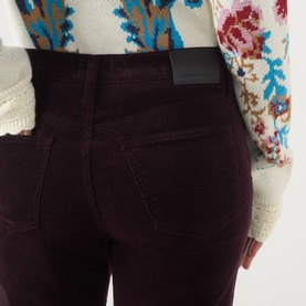 Model wearing Citizens of Humanity straight jeans in eggplant corduroy, close-up of back pockets and waistband with black leather tab.