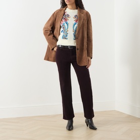 Model wearing Citizens of Humanity eggplant straight jeans, styled with a brown blazer, graphic knit top and black ankle boots.