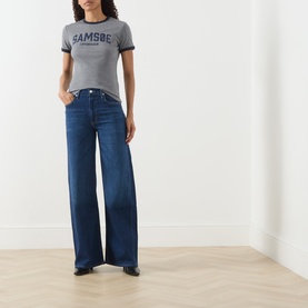 Model wearing Citizens of Humanity Wide Leg jeans in elm dark blue denim, styled with a grey logo ringer tee and black loafers