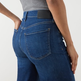 Model wearing Citizens of Humanity Wide Leg jeans in elm, close-up of back pockets and high waist detail in mid-blue denim.