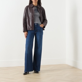 Model wearing Citizens of Humanity Wide Leg Jeans in elm, styled with dark brown leather jacket and grey graphic tee