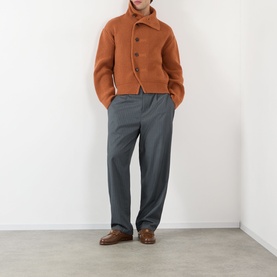 Model wearing Dries Van Noten Marino Rib-Knit Cardigan in Ocra, button-front wool knit, styled with grey trousers and brown loafers.