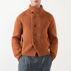 Model wearing Dries Van Noten Marino Rib-Knit Cardigan in Ocra, ribbed wool with funnel neck and front button fastening, styled with grey trousers.